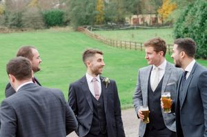 Groomsmen in grey suits chatting outdoors at Boyne Hill House Estate, wedding venue in  Co.Meath
