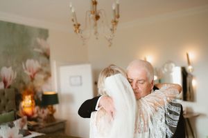 A bride and father share a tender embrace in an elegant room at Boyne Hill House Estate, Co. Meath