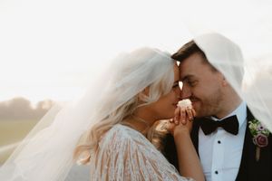 Bride and groom sharing a romantic kiss at golden hour, with flowing veil and classic black tuxedo Boyne Hill House Estate, Co. Meath