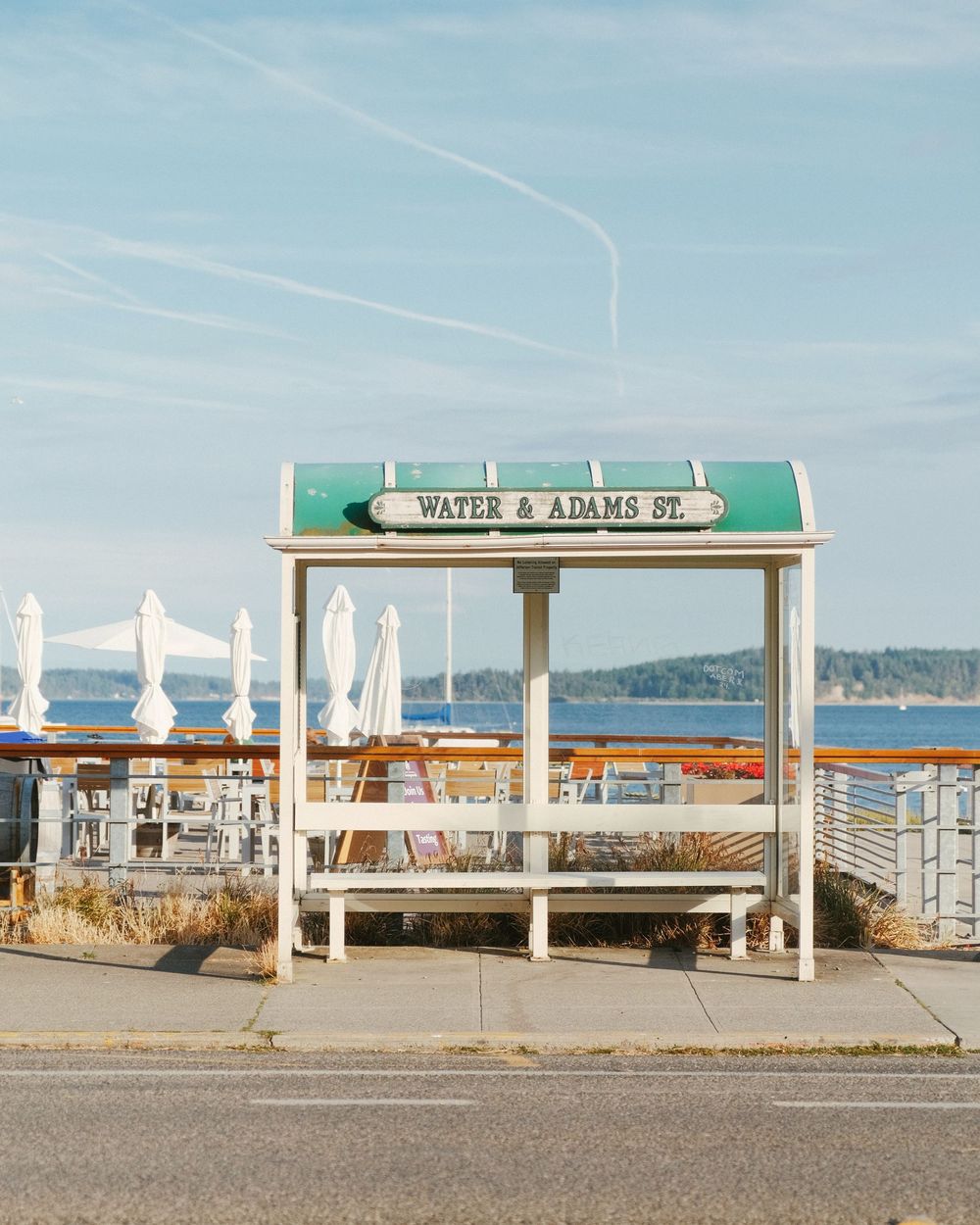 Seaside pavilion with white benches overlooking the water, travel photography
