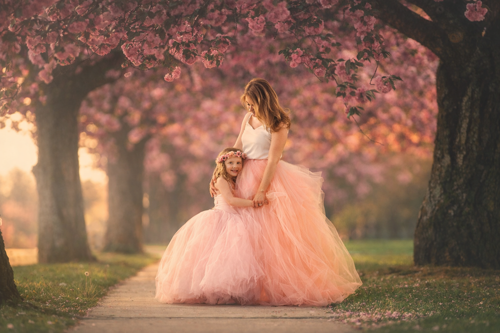 Mother and daughter sharing a sweet moment beneath cherry blossoms during a Mommy and Me session in Cherry Hill, NJ.