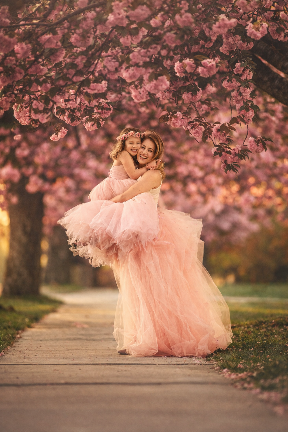 Mom and daughter smiling together among blooming cherry blossom trees in Cherry Hill, New Jersey.