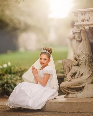 Young girl posing for her First Holy Communion portraits in a beautiful communion dress.