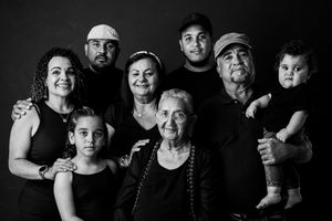 Black and white family portrait of multigenerational group including elderly woman, adults, and children posing together.