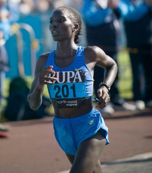 Female runner wearing BUPA number 201 competing in North East England road race event.