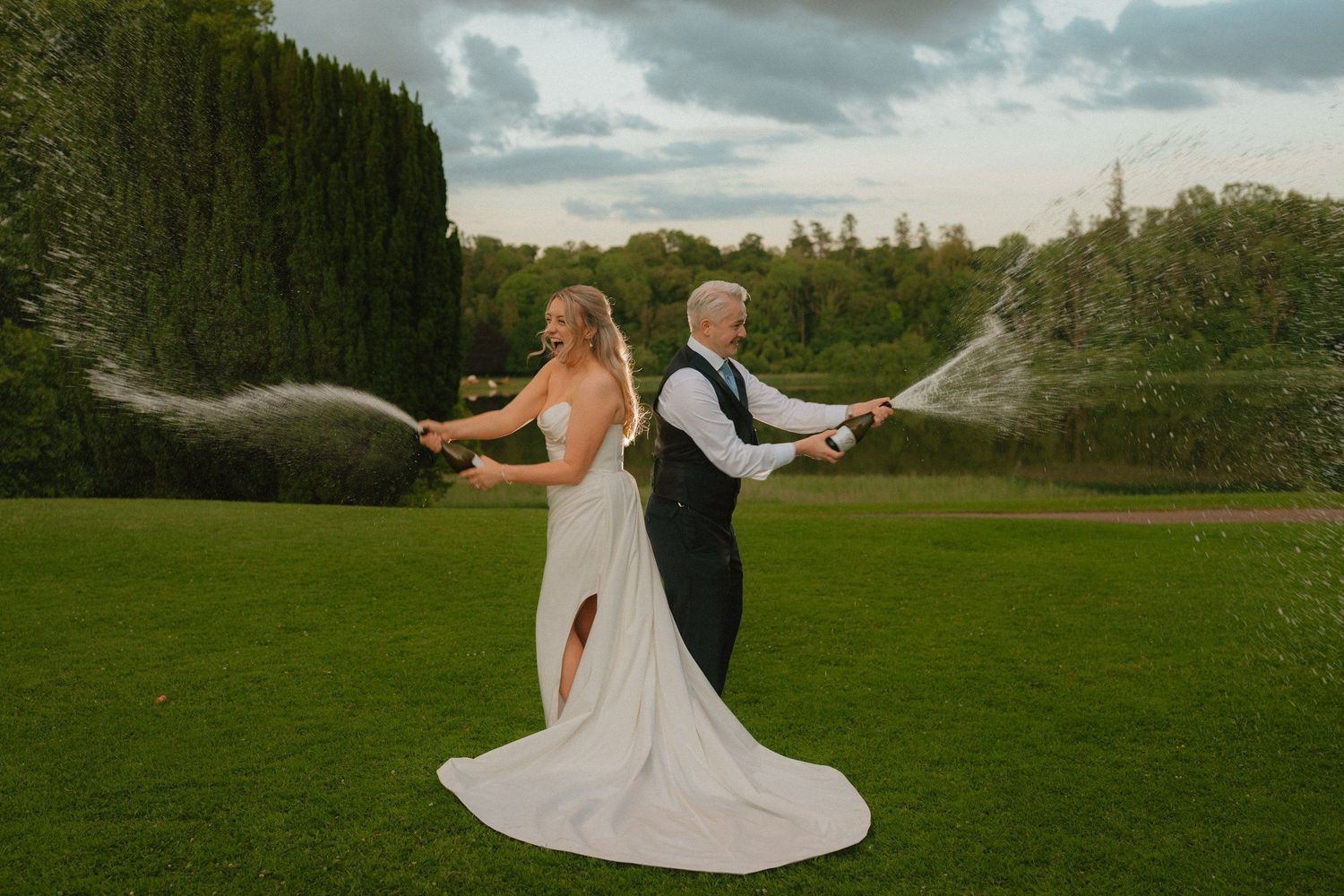 Bride and groom spraying champagne in the gardens at Castle Leslie.