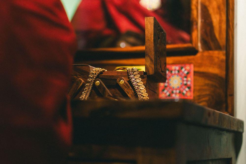 Close-up of a wooden dresser with traditional accessories and a decorative card in warm lighting.