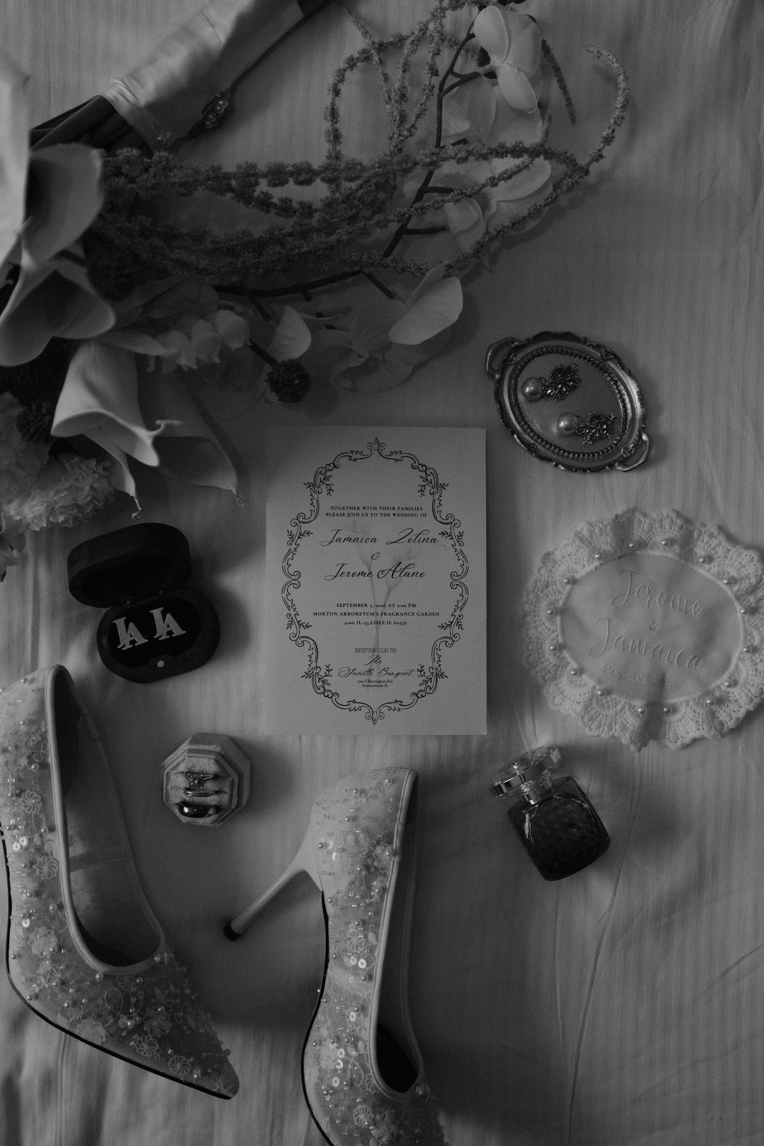 Candles glowing on a dark mantle with pearl necklace and purple beads beside ornate mirror.