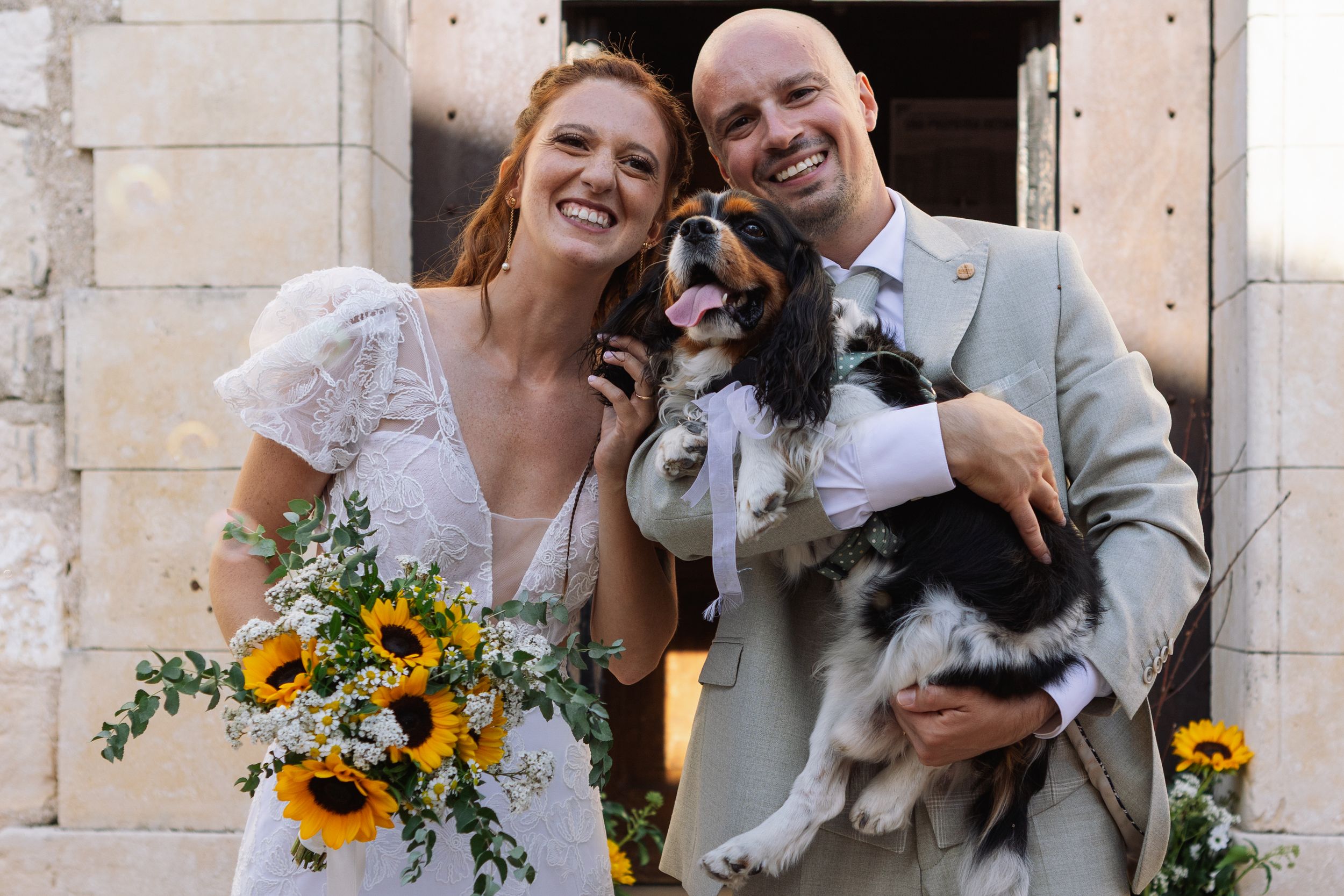 Sposi sorridenti con il loro cane dopo la cerimonia