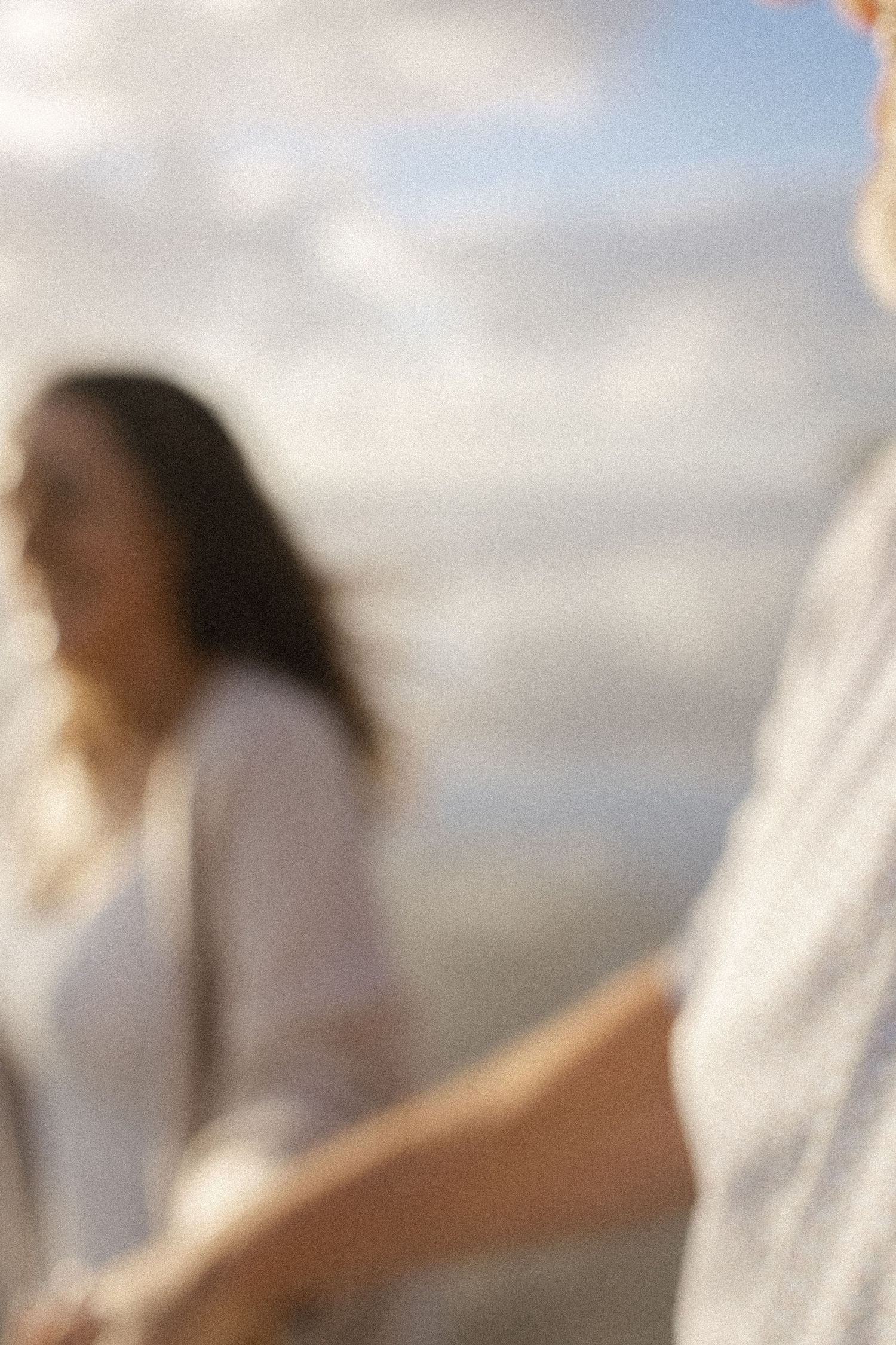 Mother lifting her baby into the bright sky during a Del Mar Beach family session.