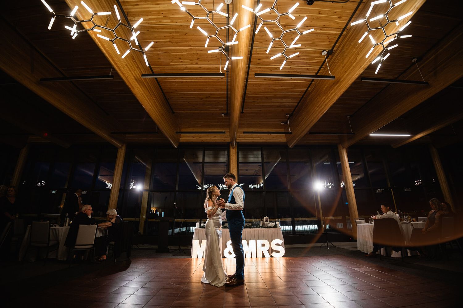 Mark and Jen's first dance under modern chandeliers at The Vista reception in Canmore