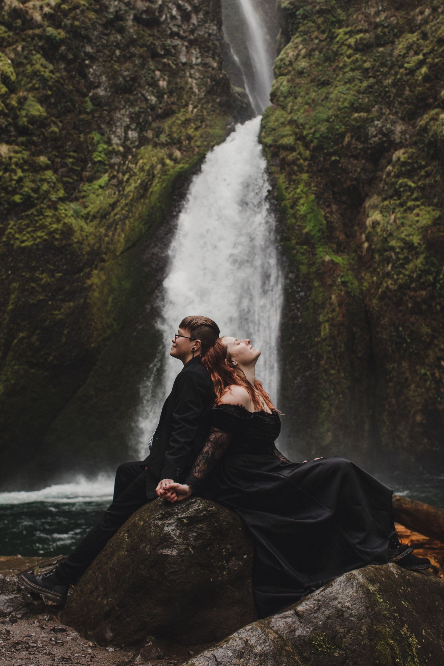 Couple resting in front of a waterfall in Washington just after their elopement ceremony.