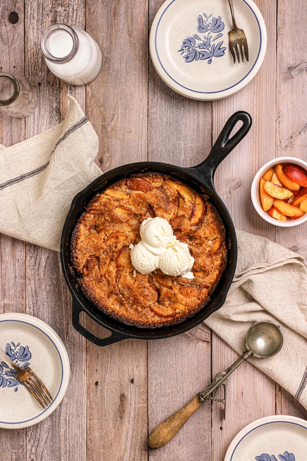 nectarine cobbler in cast iron skillet with ice cream