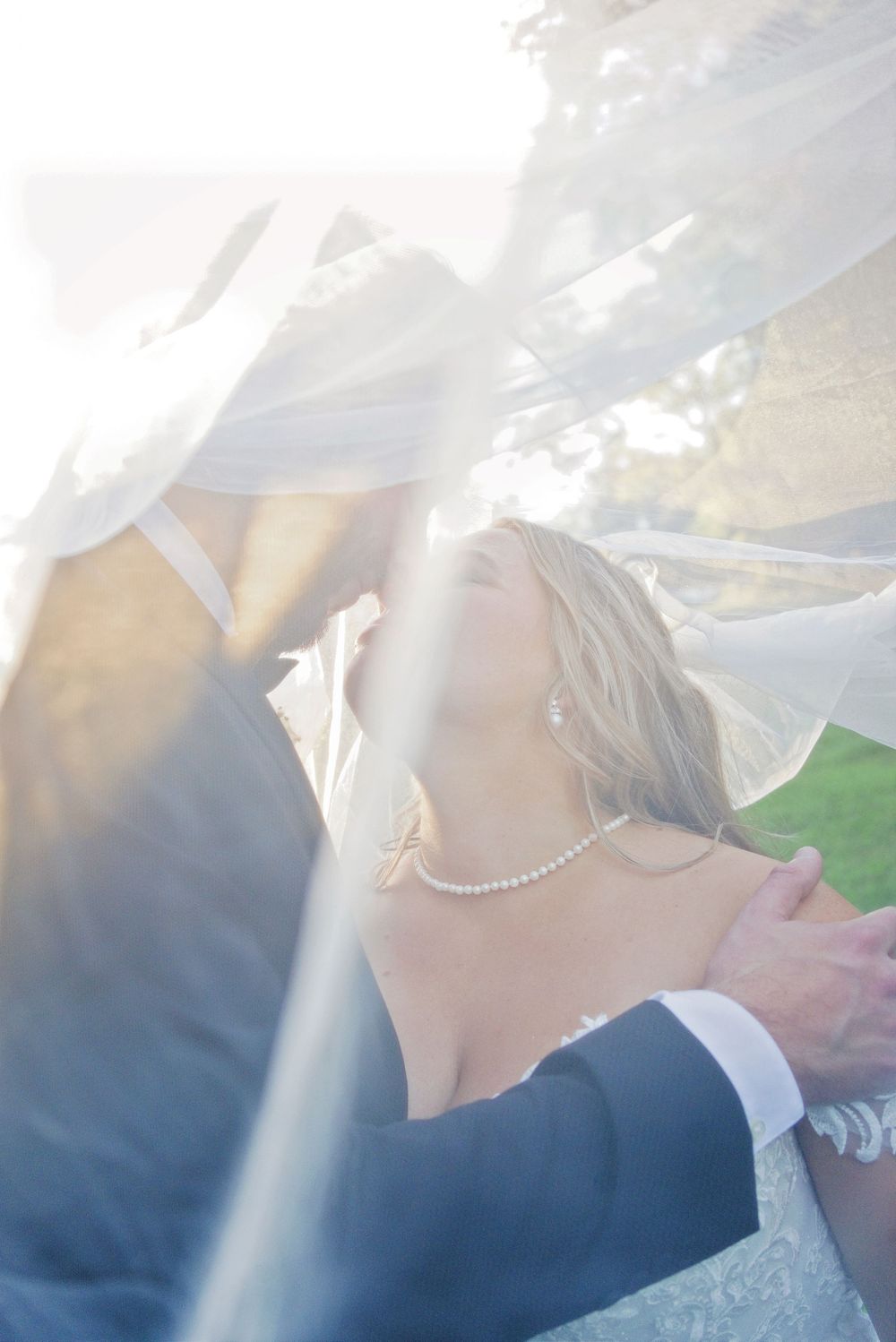 Romantic under-the-veil portrait by a Southwest Michigan photo and video team at a sunset Augusta Creek wedding.