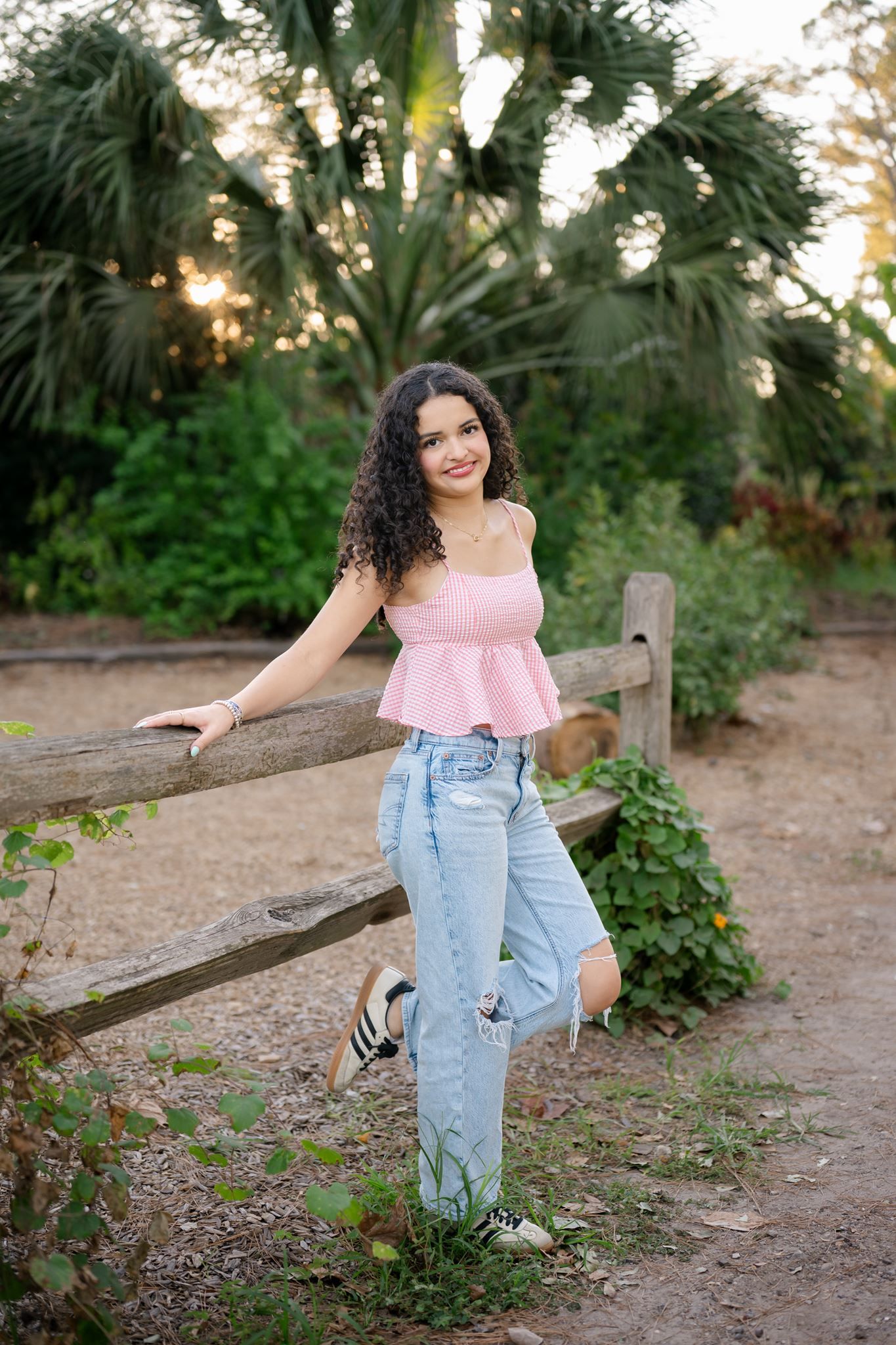 Cristina smiling during her outdoor senior photography session at Mercer Botanic Gardens.