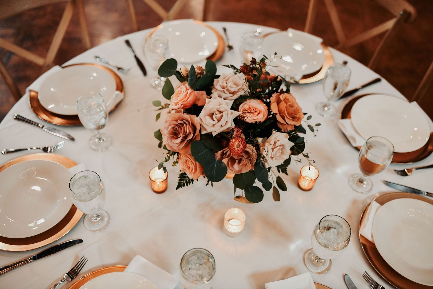 Romantic fall wedding reception details with gold accents and greenery