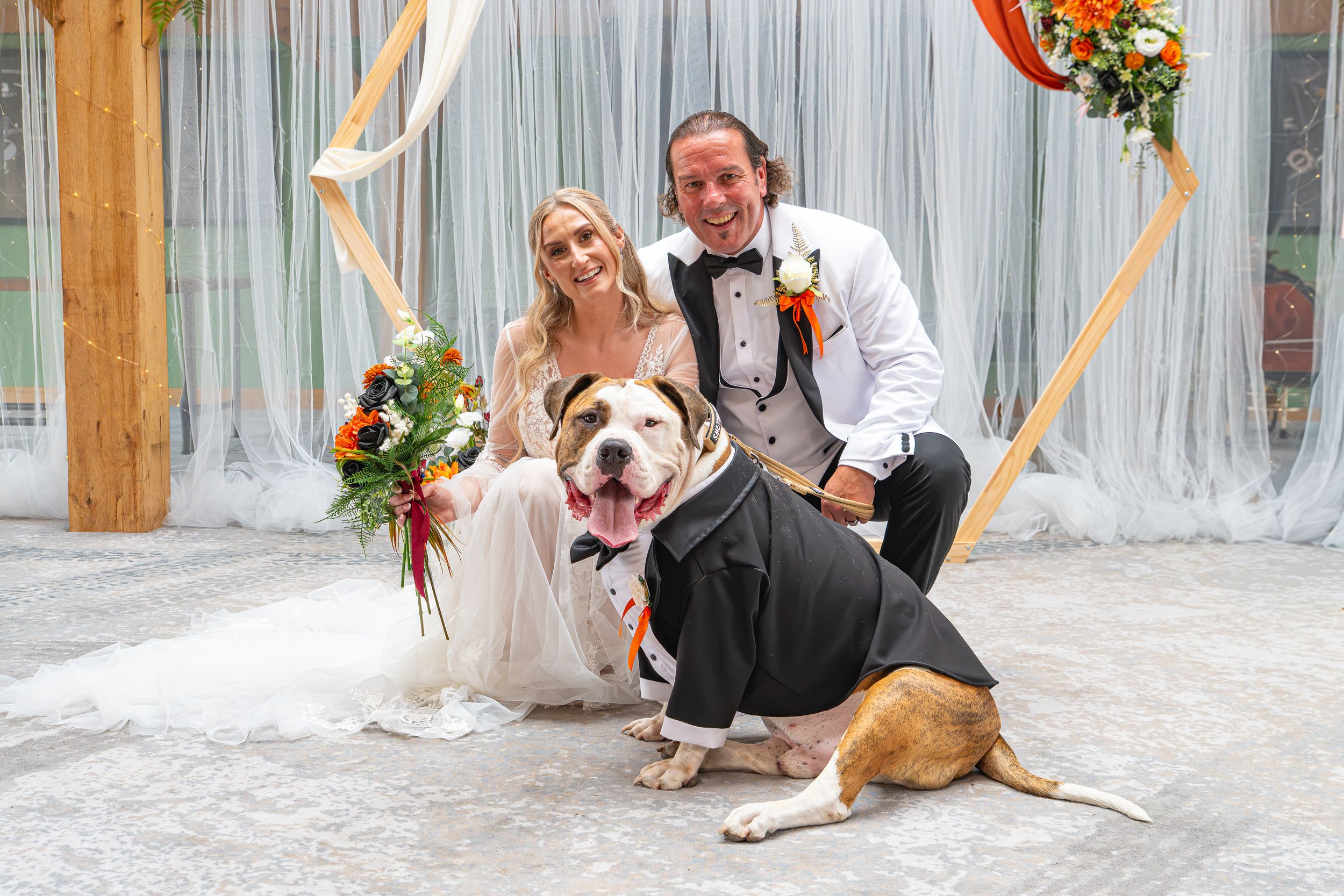 Bride and groom posing with their dog dressed in a tuxedo at their wedding ceremony. Rotherham, Sheffield, Leeds South Yorkshire