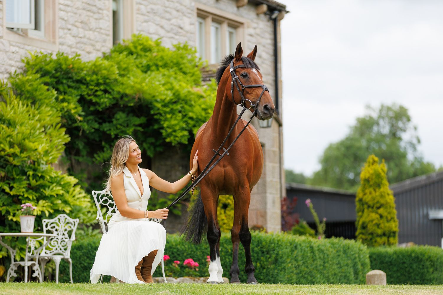 A horse and its rider enjoy an outdoor photoshoot session near rustic wooden fencing on a sunny day.