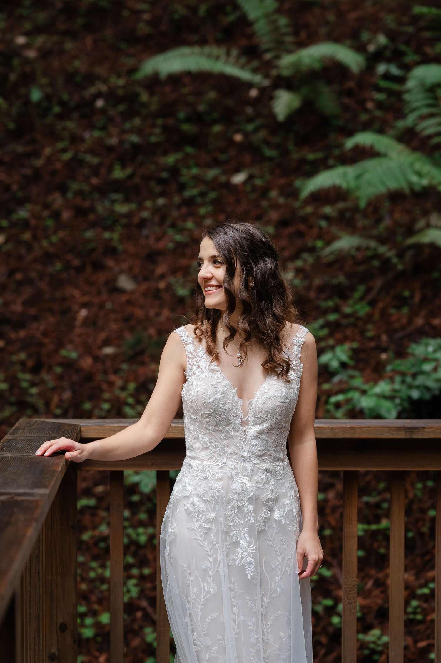 Bride wearing a pearl and silver pendant necklace with a white lace wedding dress.