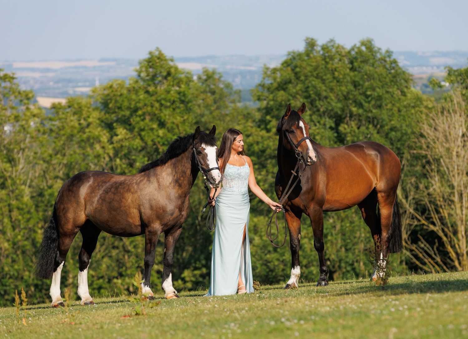A horse and its rider enjoy an outdoor photoshoot session near rustic wooden fencing on a sunny day.