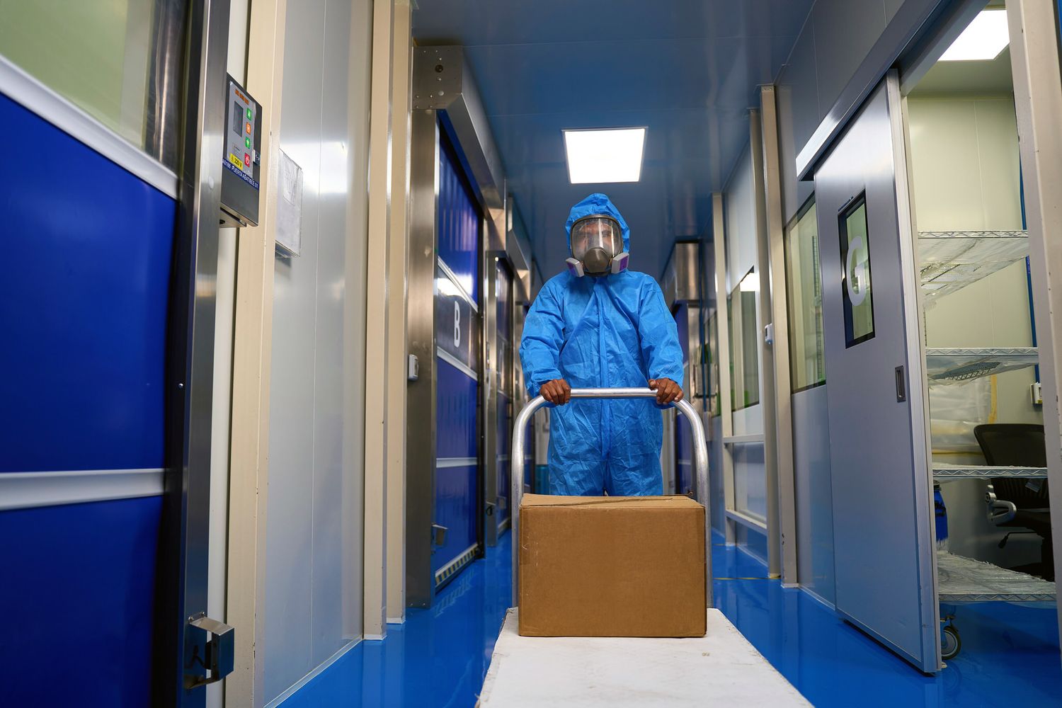 Personal con equipo de protección transportando materiales en instalaciones de planta química