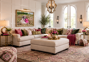 Elegant living room with cream sectional sofa, colorful throw pillows, floral rug, gold chandelier, and arched windows.