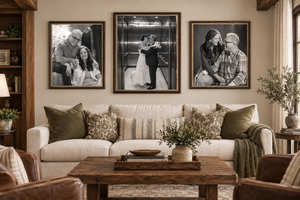 Cozy living room with a white sofa, rustic wood coffee table, and three black-and-white family portrait photos on the wall.