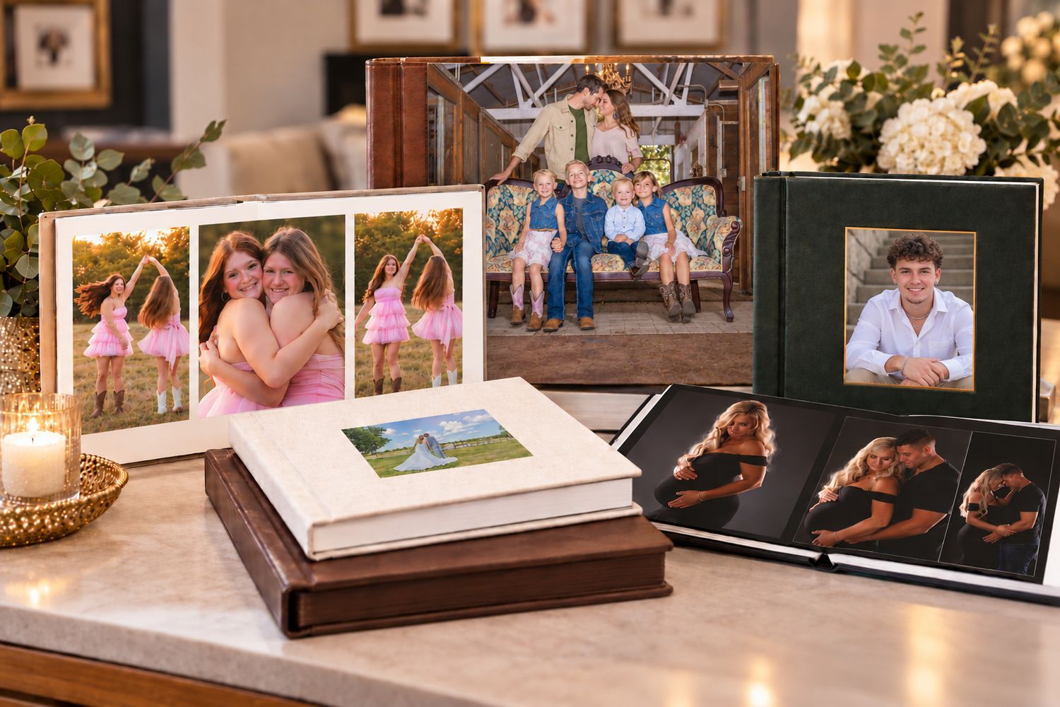 Elegant photo books displayed on a marble table featuring family and couple portraits in decorative leather-bound albums.