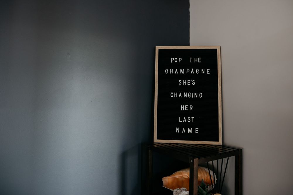 Black letterboard with white text about champagne displayed against gray wall.