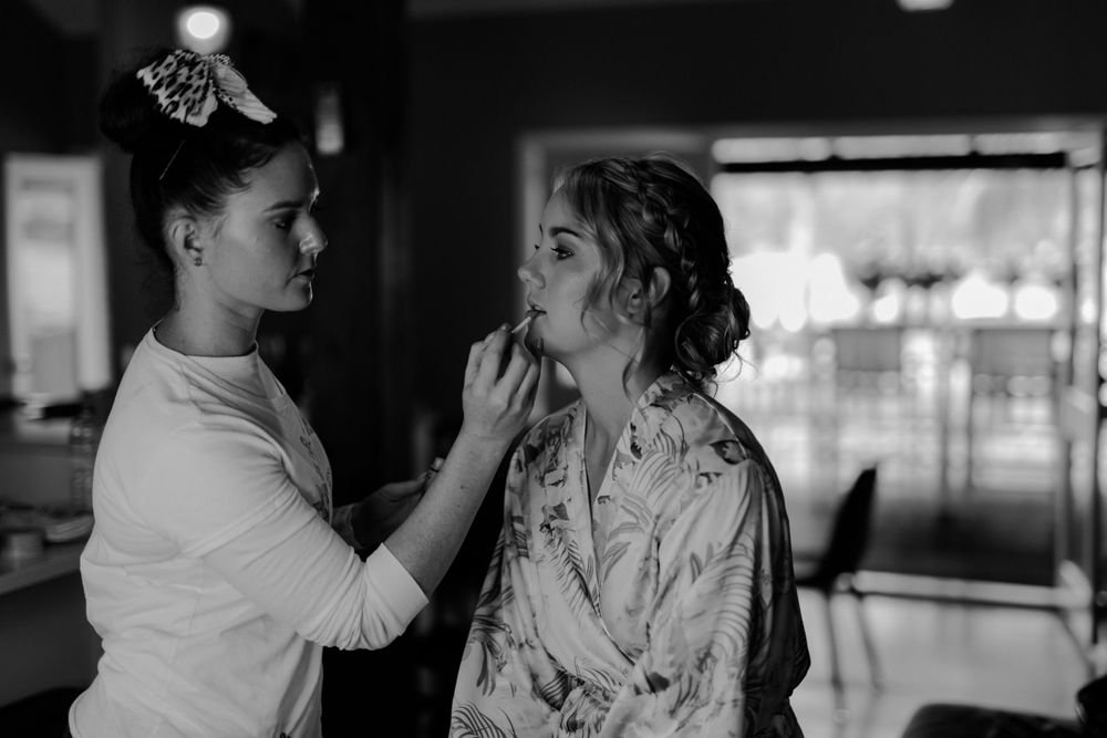 Black and white image of wedding day makeup preparation.