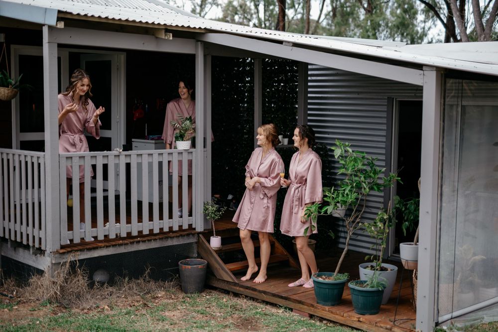 People in matching pink robes relaxing on a covered porch.