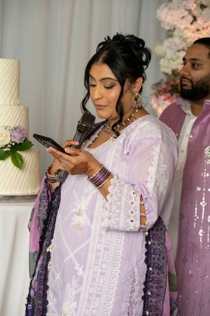 Wedding couple shares a sweet moment while cutting their elegant white tiered cake at their reception celebration.