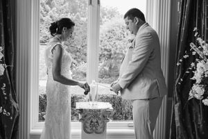 Wedding guests celebrate and dance together during an indoor reception in black and white photography.