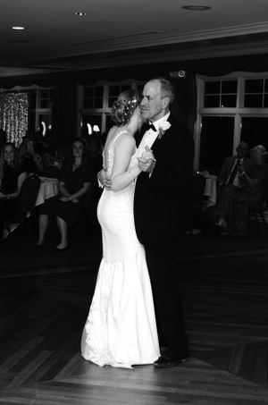Black and white photo of dance on parquet floor during wedding reception.