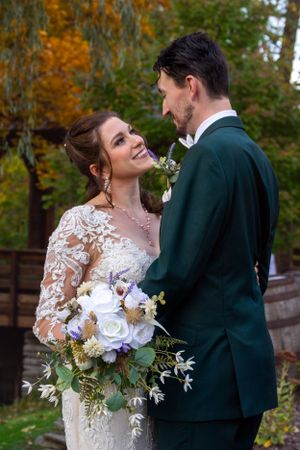 Autumn wedding portrait with bouquet featuring white flowers and greenery.