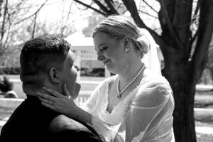 A vintage black and white photograph showing a romantic moment between a couple outdoors.
