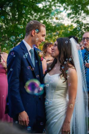 Romantic wedding moment with soap bubbles floating around the couple during their celebration.