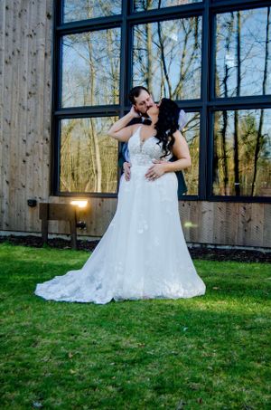Romantic wedding portrait against a modern barn window with natural light.