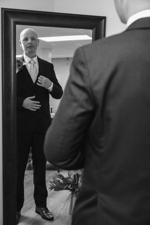 Black and white candid photos of people in formal attire preparing for a wedding ceremony.
