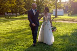 A couple shares romantic moments in a sunlit park during golden hour as they pose for wedding photos on lush grass.