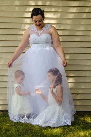 Creative wedding dress photo showing children playing beneath the tulle skirt.