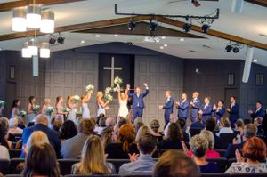Wedding celebration in a church with people raising their hands in celebration.