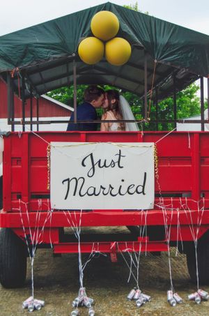 A red wedding cart decorated with yellow balloons and a 'Just Married' sign showcases a romantic moment.