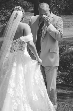 A tender first look moment captured in black and white during an outdoor wedding ceremony.