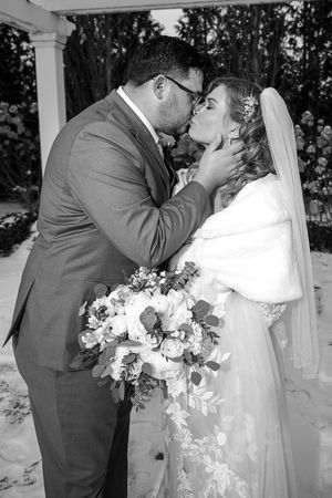 Black and white wedding photo sequence showing newlyweds sharing their first kiss as a married couple at outdoor ceremony.