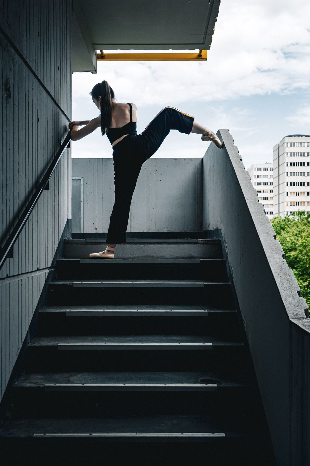 Silhouette d'une danseuse en mouvement dans un escalier urbain à Lyon.
