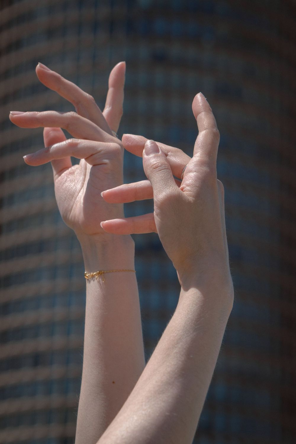 Détail des mains d'une danseuse en mouvement devant la tour Part-Dieu à Lyon.