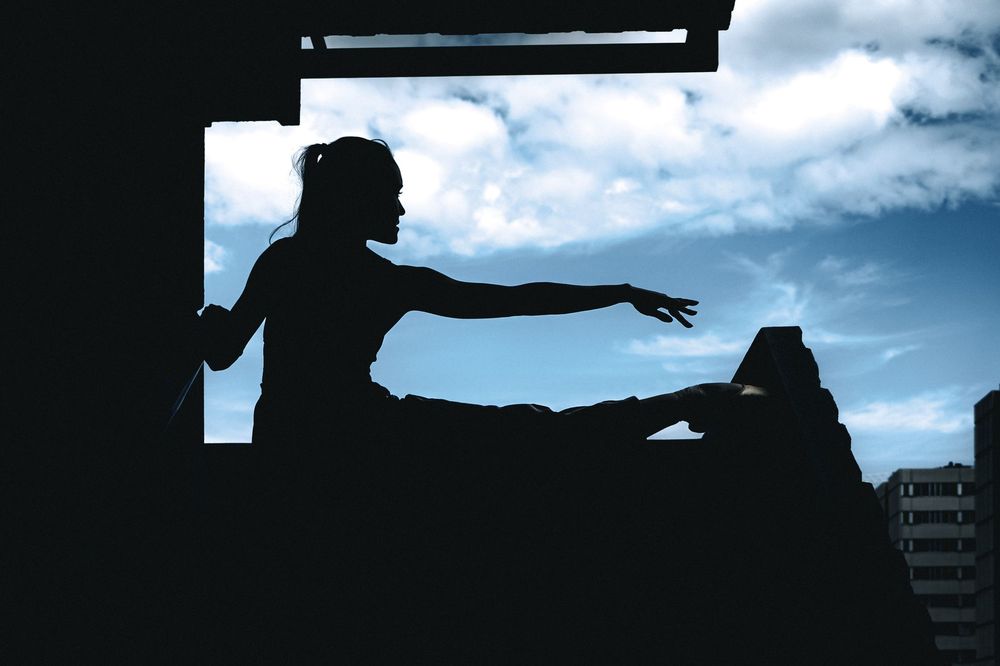 Silhouette d'une danseuse découpée sur le ciel, explorant le dialogue entre le corps et la ville.