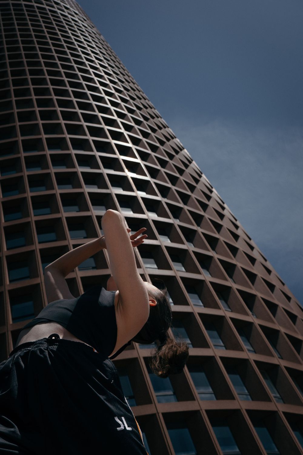 Danseuse photographiée en contre-plongée au pied de la tour Part-Dieu à Lyon.