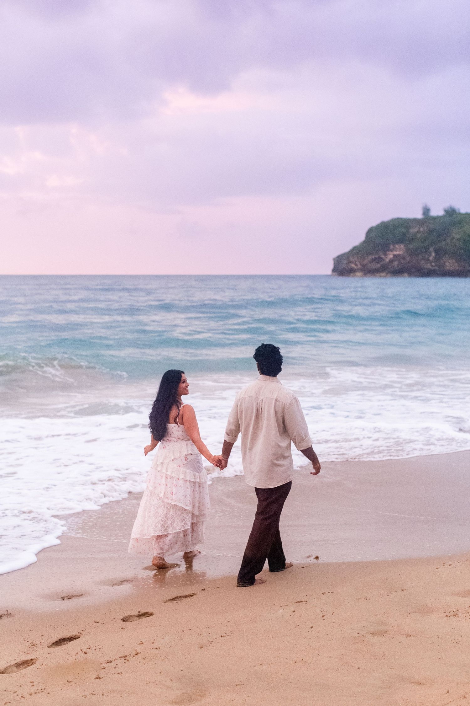 Engagement portrait on the beach. Man and woman walking along the water's edge. Playa Guajataca, Isabela, Puerto Rico.